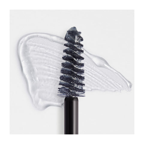 Close-up of a RevitaLash Hi-Def Brow Gel brush on a white surface, coated with the gel and showing smudged texture and transparency. The word CLEAR is printed in the top right corner.