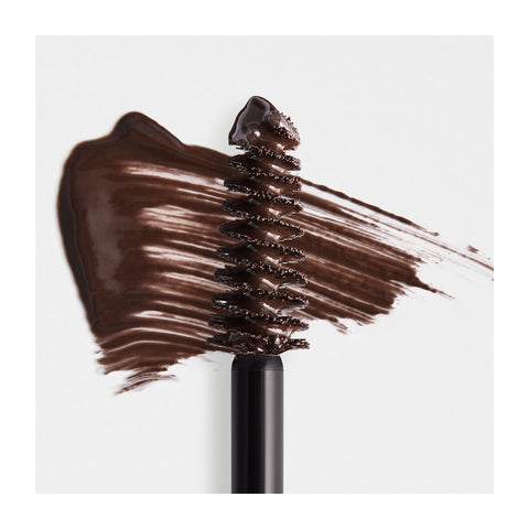 The RevitaLash Hi-Def Brow Gel in dark brown is showcased against a white background, with its precision styling brush highlighting smooth, rich streaks and a creamy texture. DARK BROWN is displayed in the top right corner.