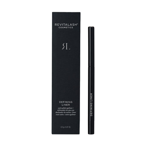 A black RevitaLash Defining Liner Eyeliner, celebrated for its high-impact color and smudge-proof finish, is displayed beside its matching black box featuring the RevitaLash logo and text. The product name is elegantly inscribed on the cream eyeliners side.