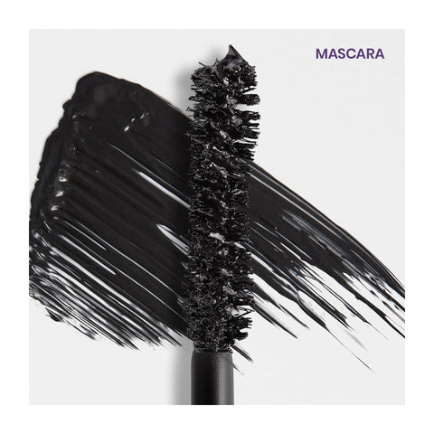 A close-up of a black volumizing wand from the RevitaLash Double-Ended 2-in-1 Lash Primer & Mascara Volume Set lies next to a thick smear on a light background, with MASCARA elegantly inscribed in purple in the top right corner, denoting RevitaLashs excellence.