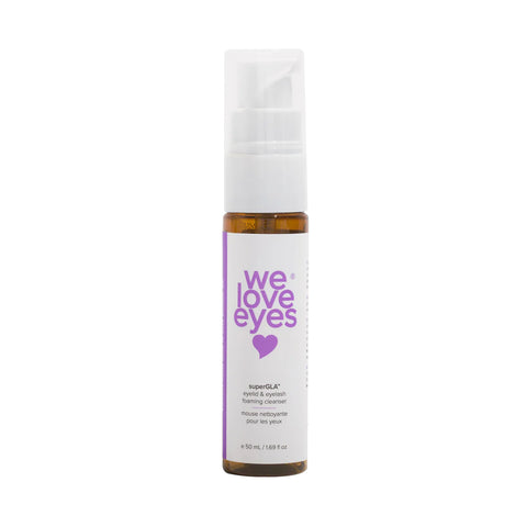 The We Love Eyes SuperGLA eyelid & eyelash foaming cleanser (50mL) features a white pump cap, a purple heart on the label, and text highlighting superGLY+ foaming cleanser. Its crafted with non-toxic ingredients specially designed to soothe dry eyes.